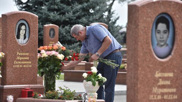 Мужчина принес цветы на могилу на мемориальном кладбище Город ангелов в Беслане, где похоронены погибшие во время теракта в 1-й Бесланской школе 1-3 сентября 2004 года Мужчина принес цветы на могилу на мемориальном кладбище Город ангелов в Беслане, где похоронены погибшие во время теракта в 1-й Бесланской школе 1-3 сентября 2004 года