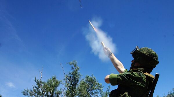 Военнослужащий ЛНР запускает сигнальную ракету белого цвета Военнослужащий ЛНР запускает сигнальную ракету белого цвета