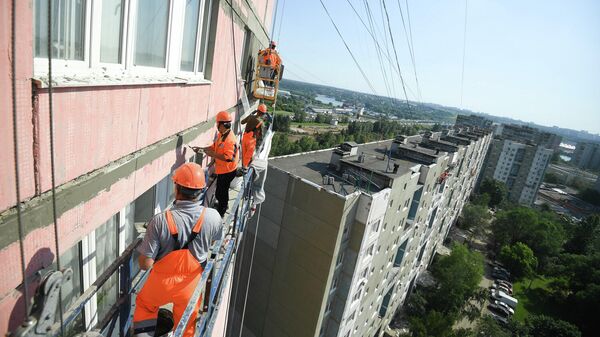 Рабочие проводят ремонт жилого дома Рабочие проводят ремонт жилого дома