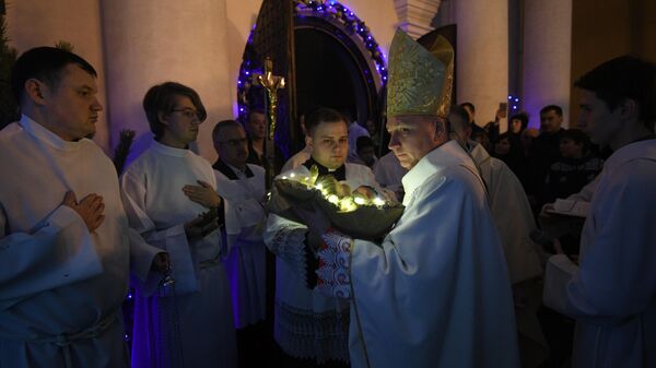 Викарный епископ Юрий Кособуцкий вносит младенца в рождественский вертеп в римско-католическом кафедральном соборе Святого Имени Пресвятой Девы Марии в Минске Викарный епископ Юрий Кособуцкий вносит младенца в рождественский вертеп в римско-католическом кафедральном соборе Святого Имени Пресвятой Девы Марии в Минске