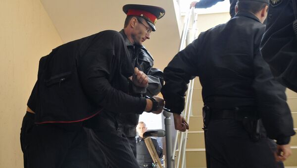Сотрудники милиции ведут одного из главных подозреваемых в деле об убийстве 12 человек в станице Кущевская, архивное фото Сотрудники милиции ведут одного из главных подозреваемых в деле об убийстве 12 человек в станице Кущевская, архивное фото