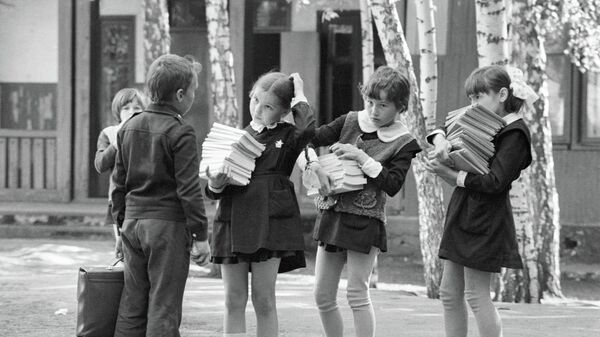 Школьники несут стопки учебников Школьники несут стопки учебников
