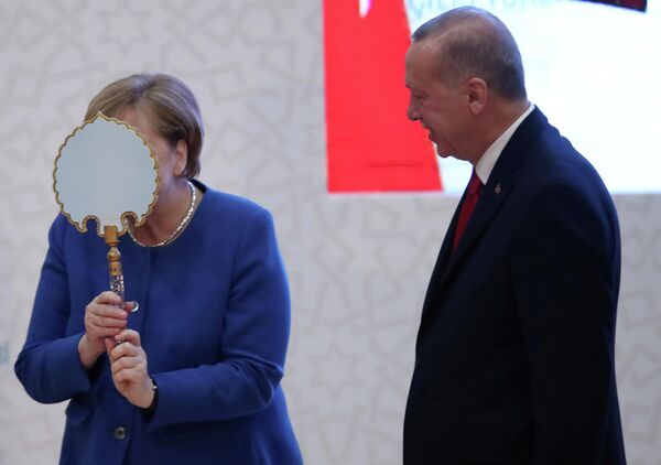 Канцлер Германии Ангела Меркель получает подарок от президента Турции Канцлер Германии Ангела Меркель получает подарок от президента Турции