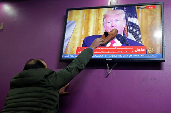 Палестинец смотрит выступление президента США Дональда Трампа по урегулированию палестино-израильского конфликта в кафе Хеврона Палестинец смотрит выступление президента США Дональда Трампа по урегулированию палестино-израильского конфликта в кафе Хеврона
