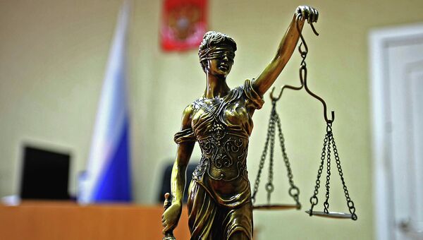 Статуэтка богини правосудия Фемиды в зале суда. Архивное фото Статуэтка богини правосудия Фемиды в зале суда. Архивное фото