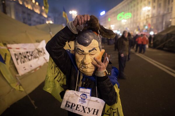 Сторонник евроинтеграции Украины в маске, изображающей президента страны Виктора Януковича, в палаточном лагере на площади Независимости в Киеве. Сторонник евроинтеграции Украины в маске, изображающей президента страны Виктора Януковича, в палаточном лагере на площади Независимости в Киеве.