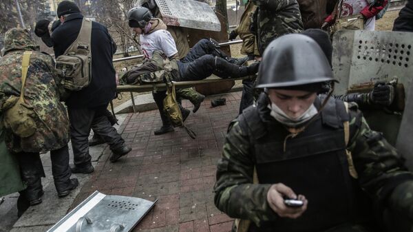 Сторонники оппозиции несут раненного во время столкновений с сотрудниками правопорядка в Киеве Сторонники оппозиции несут раненного во время столкновений с сотрудниками правопорядка в Киеве