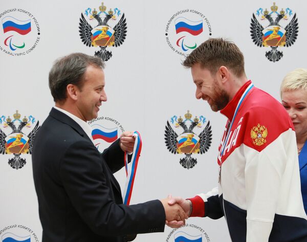 Заместитель председателя правительства РФ Аркадий Дворкович (слева) награждает паралимпийца Сергея Малышева Заместитель председателя правительства РФ Аркадий Дворкович (слева) награждает паралимпийца Сергея Малышева