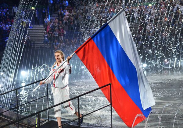 Знаменосец сборной России - олимпийская чемпионка по синхронному плаванию Наталья Ищенко на церемонии открытия XVI чемпионата мира по водным видам спорта в Казани Знаменосец сборной России - олимпийская чемпионка по синхронному плаванию Наталья Ищенко на церемонии открытия XVI чемпионата мира по водным видам спорта в Казани